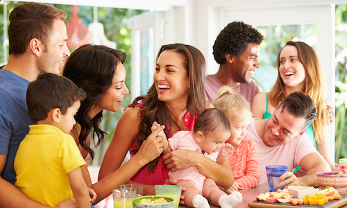 Group Of Families Enjoying Snacks At Home